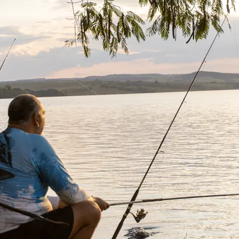 Pescador na margem do Lago Corumbá IV no fim da tarde